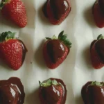 Fresh strawberries dipped in melted chocolate on a tray